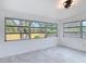 Bright bedroom featuring white walls, light tile flooring, a modern light fixture and multiple windows at 1113 Leeward Dr, Deltona, FL 32738