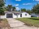 Charming stucco home with a driveway, well-maintained lawn, and an attached carport at 1113 Leeward Dr, Deltona, FL 32738