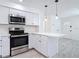 Kitchen featuring stainless steel appliances, white cabinets, and breakfast bar at 1113 Leeward Dr, Deltona, FL 32738
