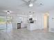 Bright, open-concept living space with new gray tile flooring and modern ceiling fan at 1113 Leeward Dr, Deltona, FL 32738