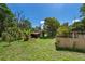Backyard featuring green grass, mature trees, and a small wooden shed at 1121 Votaw Rd, Apopka, FL 32703
