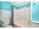 Bathroom featuring a bathtub and shower with white tile walls and turquoise accent paint at 1121 Votaw Rd, Apopka, FL 32703