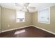 Cozy bedroom with hardwood floors, two windows, and a ceiling fan with lights at 1121 Votaw Rd, Apopka, FL 32703