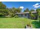 A charming single-story home with green grass, tropical landscaping and a partially fenced yard at 1121 Votaw Rd, Apopka, FL 32703