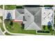 An aerial view shows a home with gray roof, a paver patio, manicured lawn and mature landscaping at 11257 Dacre Ln, Orlando, FL 32824