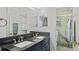 Bathroom featuring double sinks with dark countertop and a walk-in shower with decorative tile at 11257 Dacre Ln, Orlando, FL 32824