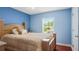 Inviting bedroom with soft blue walls, hardwood floors, and a comfortable bed near a bright window at 11257 Dacre Ln, Orlando, FL 32824