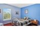 Bright bedroom with blue walls, hardwood flooring and window view at 11257 Dacre Ln, Orlando, FL 32824