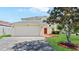 Two-story home with a two car garage, brick driveway, and bright red front door at 11257 Dacre Ln, Orlando, FL 32824