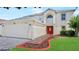Two-story home with a two car garage, tile walkway, and bright red front door at 11257 Dacre Ln, Orlando, FL 32824