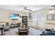 Cozy living room featuring a ceiling fan, media center with TV, and neutral tile flooring at 11257 Dacre Ln, Orlando, FL 32824