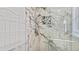 Modern shower design featuring marble-patterned tiles, mosaic accents, and sleek fixtures at 11257 Dacre Ln, Orlando, FL 32824