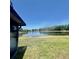 Picturesque backyard overlooking a serene pond surrounded by mature trees under a clear sky at 11373 Darlington Dr, Orlando, FL 32837