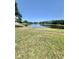 Backyard featuring a scenic pond view, bordered by green grass and a sturdy chain-link fence at 11373 Darlington Dr, Orlando, FL 32837