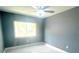 Bright bedroom with natural light from the window and modern gray walls with sleek white tile floor at 11373 Darlington Dr, Orlando, FL 32837
