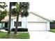 Charming one-story home with a two-car garage, featuring two palm trees in the front yard at 11373 Darlington Dr, Orlando, FL 32837