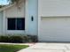 Close up view of the light blue exterior with the front of a white garage at 11373 Darlington Dr, Orlando, FL 32837