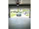 View of spacious garage that houses a luxury car with an open door to a well-manicured lawn at 11373 Darlington Dr, Orlando, FL 32837