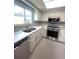 Modern kitchen featuring stainless steel appliances, white cabinets, stone countertops and a large window at 11373 Darlington Dr, Orlando, FL 32837