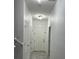 Well-lit hallway with neutral walls, tiled floor, and several doors at 11464 Center Lake Dr, Windermere, FL 34786