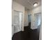 Bright hallway leading to bathroom with tiled shower/tub and multiple rooms with dark, wood-look flooring at 11464 Center Lake Dr, Windermere, FL 34786