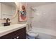 Bathroom vanity with round mirror and a shower-tub combination with a tiled wall at 115 Tomoka Trl # 115, Longwood, FL 32779