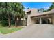 Beige two-story condo with car port and second story balcony, palm trees and green grass at 115 Tomoka Trl # 115, Longwood, FL 32779