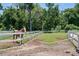 Horse paddock with green grass, white fencing, and shady trees offers a safe, spacious environment for animals at 115 Tomoka Trl # 115, Longwood, FL 32779