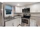 Bright kitchen boasts white cabinets, granite countertops, and stainless steel appliances at 115 Tomoka Trl # 115, Longwood, FL 32779