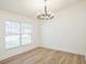 Dining room with hardwood floors, modern chandelier, and a large bright window at 117 Sanderling Dr, Haines City, FL 33844