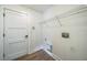 The laundry room features wood-look flooring and a hanging wire shelf above the washer/dryer hookups at 117 Sanderling Dr, Haines City, FL 33844