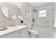 Stylish bathroom featuring a tub with marble tile surround, a vanity, and a large round mirror at 1195 Tivoli Dr, Deltona, FL 32725