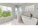 Elegant bathroom featuring a modern tub, a glass shower, and marble tile at 1195 Tivoli Dr, Deltona, FL 32725