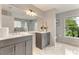 Bright bathroom featuring double vanity sinks with white countertops and gray cabinets at 1195 Tivoli Dr, Deltona, FL 32725