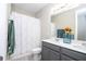 Bathroom featuring gray cabinets, double sinks and a shower with a white shower curtain at 12133 Bracco St, Winter Garden, FL 34787