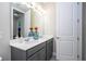 Bathroom featuring gray cabinets, white countertop, double sinks and a white door at 12133 Bracco St, Winter Garden, FL 34787