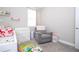Bright Bedroom showcasing a rocking chair, crib, changing table, and plush carpeting at 12133 Bracco St, Winter Garden, FL 34787