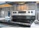 Close up of stainless steel stove with tile backsplash and quartz countertop at 12133 Bracco St, Winter Garden, FL 34787
