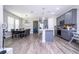 Open kitchen/dining area with stainless appliances, gray cabinets, and modern lighting at 12133 Bracco St, Winter Garden, FL 34787