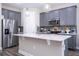 Well-equipped kitchen features stainless steel appliances, gray cabinets, and a spacious quartz island at 12133 Bracco St, Winter Garden, FL 34787