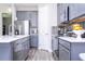 Modern kitchen featuring stainless steel appliances, gray cabinetry, and quartz countertops at 12133 Bracco St, Winter Garden, FL 34787