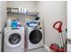 Well-organized laundry room features modern washer and dryer, storage shelves, and tiled flooring at 12133 Bracco St, Winter Garden, FL 34787