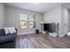 Cozy living room featuring wood floors, bright windows, and modern entertainment setup at 12133 Bracco St, Winter Garden, FL 34787
