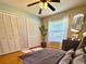 Well-lit bedroom with a ceiling fan, wood floors, neutral paint and generous closet space at 1219 Serissa Ct, Orlando, FL 32818