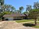 Charming single-story home with a well-maintained lawn, mature trees, and a two-car garage providing ample parking at 1219 Serissa Ct, Orlando, FL 32818
