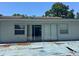 Rear exterior with sliding glass doors leading to an aging wooden deck at 1219 Serissa Ct, Orlando, FL 32818