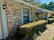 A close up of the side of the home showing brick siding, trimmed hedges, and a sidewalk at 1219 Serissa Ct, Orlando, FL 32818