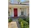 Inviting front entrance with a vibrant red door, stylish sconces, and neatly manicured shrubs enhancing curb appeal at 1219 Serissa Ct, Orlando, FL 32818