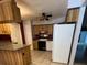 Compact kitchen with a view of white appliances and light wood cabinets with dark countertops at 1219 Serissa Ct, Orlando, FL 32818