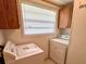 Functional laundry room featuring appliances, cabinet space, and natural light at 1219 Serissa Ct, Orlando, FL 32818
